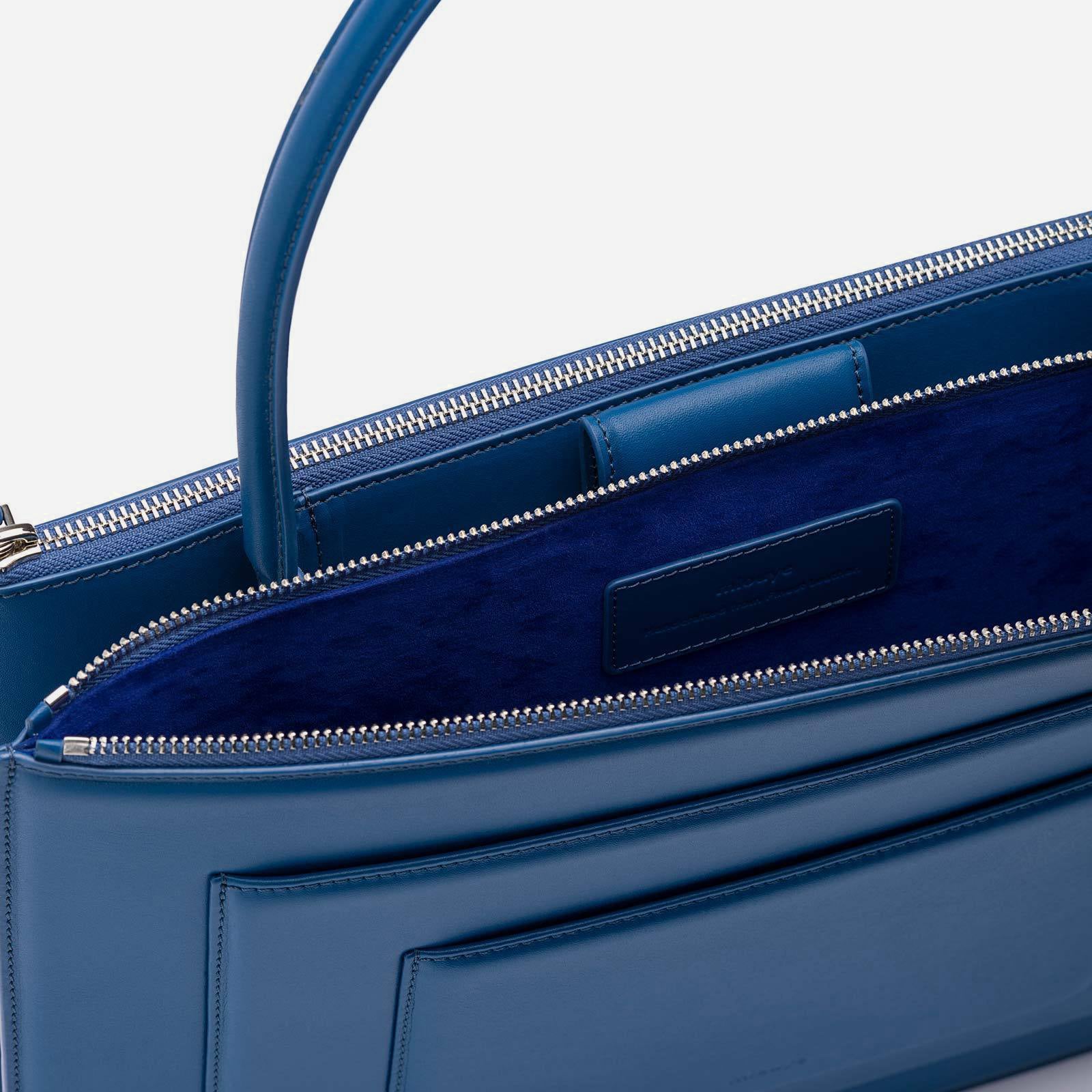 Detail view of blue purse's zipper enclosure and suede interior
