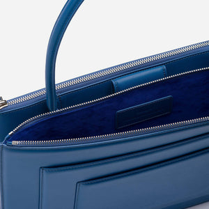 Detail view of blue purse's zipper enclosure and suede interior
